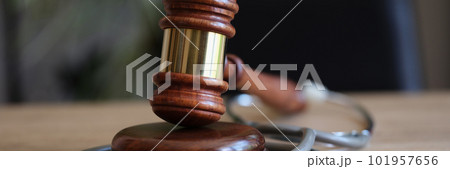 Judge gavel and medical stethoscope on office desk Judge gavel and medical stethoscope on office desk 101957656