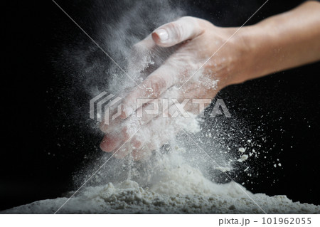 Female hands sift flour with a metal sieve on a black background. Female hands sift flour with a metal sieve on a black background. 101962055