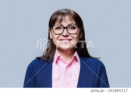 Close-up portrait of middle aged woman on grey studio background 101965217