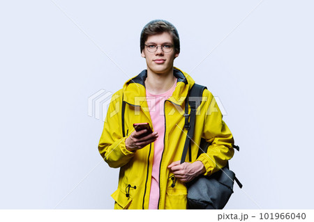 Trendy young male in yellow jacket hat using smartphone on white background Trendy young male in yellow jacket hat using smartphone on white background 101966040