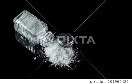 Heap of salt from a salt shaker on black background. The concept of excessive salt intake that can be the cause of diabetes or other diseases Heap of salt from a salt shaker on black background. The concept of excessive salt intake that can be the cause of diabetes or other diseases 101966425