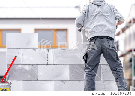 a mason builds the wall of a building from concrete bricks and blocks a mason builds the wall of a building from concrete bricks and blocks 101967234