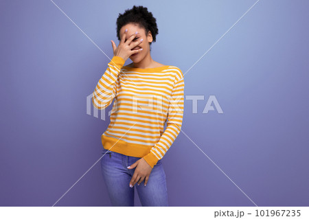 portrait latin young woman with a ponytail of afro hair covers her face with her hand portrait latin young woman with a ponytail of afro hair covers her face with her hand 101967235
