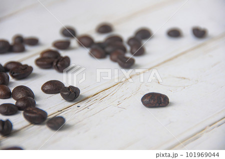 Scattered coffee beans on wooden cover background with customizable space for text or coffee ideas. Scattered coffee beans on wooden cover background with customizable space for text or coffee ideas. 101969044
