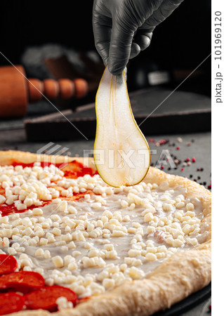 Making a pizza putting pear on a dough Making a pizza putting pear on a dough 101969120