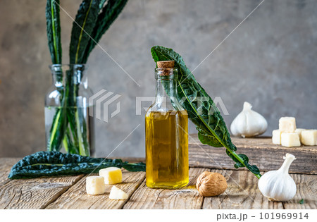 Ingredients for homemade kale - kale leaves, walnuts, parmesan, garlic and olive oil on wooden surface with grey background  101969914