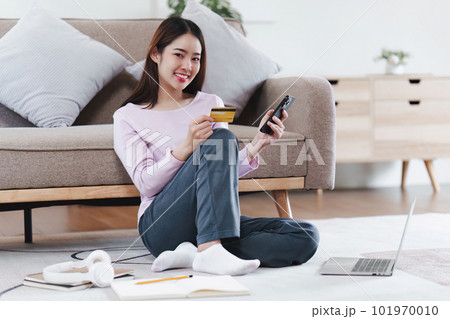 Attractive Asian Woman shopping online by smart phone and paying with credit card, online payment, shopping online, e-commerce, internet banking 101970010