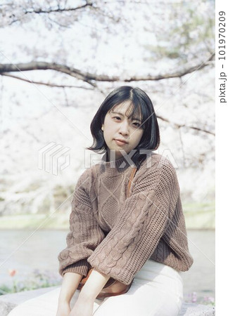川沿いの桜の下でポーズをとる女性 川沿いの桜の下でポーズをとる女性 101970209