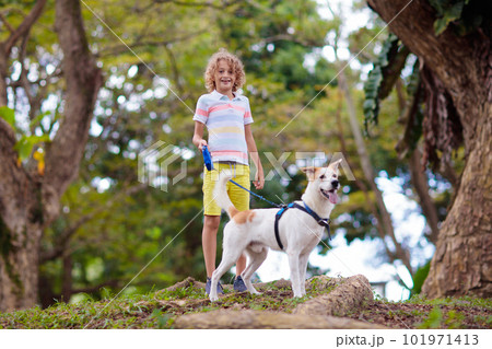 Child and dog walk in summer park 101971413