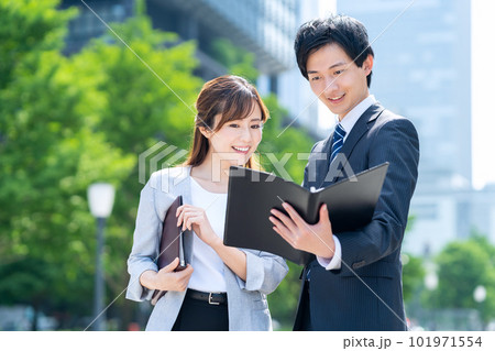 オフィス街で打ち合わせをするビジネスマンの男女 オフィス街で打ち合わせをするビジネスマンの男女 101971554
