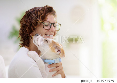 Woman with puppy. Curly girl holding little dog. Woman with puppy. Curly girl holding little dog. 101971579
