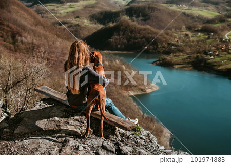 Woman and Dog on Mountain Top above Lake 101974883