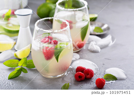 Cold summer cocktail with limes and raspberry 101975451