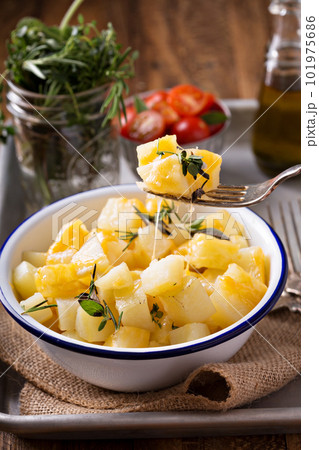 Potato with cheese and herbs prepared on a grill 101975686