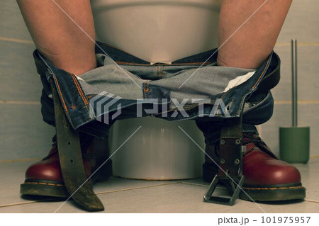 A man sitting on the toilet. A concept from the 1980s. Red punk shoes and jeans 101975957