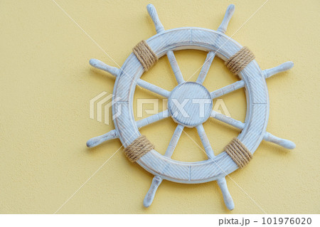 White marine steering wheel on light background. Sea voyages and adventures. Vacation on yacht. Promotional postcards. White marine steering wheel on light background. Sea voyages and adventures. Vacation on yacht. Promotional postcards. 101976020