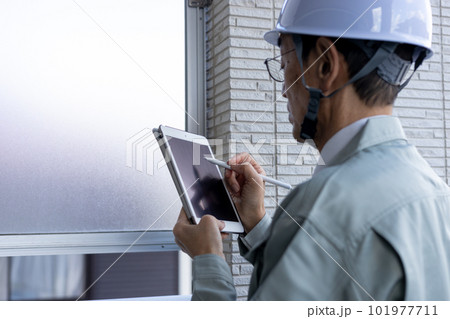 一戸建てのベランダの外壁を点検している男性作業員 101977711
