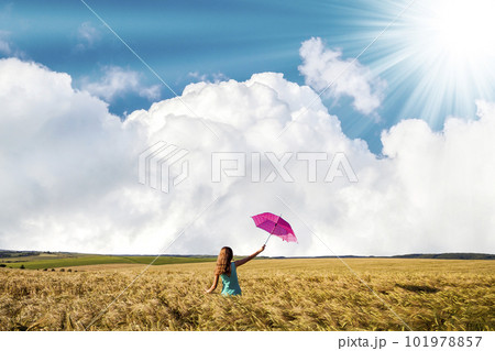 Beauty young girl outdoors enjoying nature. Beautiful teenage model girl in blue dress with red umbrella on the wheat field in rays of sun light. Beauty young girl outdoors enjoying nature. Beautiful teenage model girl in blue dress with red umbrella on the wheat field in rays of sun light. 101978857