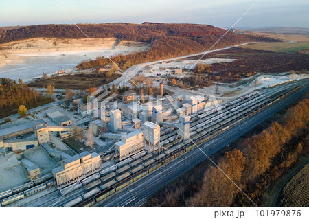 Aerial view of cargo train loaded with crushed stone materials at mining factory. Railway transportation of grinded limestone ore Aerial view of cargo train loaded with crushed stone materials at mining factory. Railway transportation of grinded limestone ore 101979876