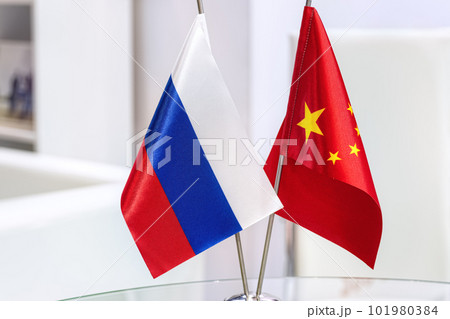 Russian and Chinese flags on glass table in meeting room. The concept of Russian Chinese cooperation. 101980384