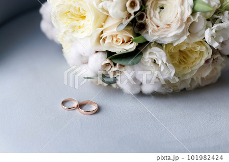 A wedding bouquet and two golden wedding rings A wedding bouquet and two golden wedding rings 101982424