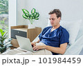 Caucasian patient using laptop in hospital room. man sick patient lying in a hospital bed 101984459