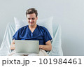 Caucasian patient using laptop in hospital room. man sick patient lying in a hospital bed 101984461