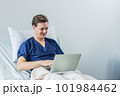 Caucasian patient using laptop in hospital room. man sick patient lying in a hospital bed 101984462