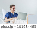 Caucasian patient using laptop in hospital room. man sick patient lying in a hospital bed 101984463