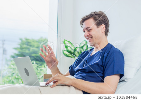 Caucasian patient using laptop in hospital room. man sick patient lying in a hospital bed Caucasian patient using laptop in hospital room. man sick patient lying in a hospital bed 101984468