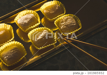 Yellow mango and lemon mochi mochies, wooden chopsticks on a golden tray top view. Asian food, sweets and delicacies. Japanese traditional confectionary ice cream made of rice flour dough. Soft focus. Yellow mango and lemon mochi mochies, wooden chopsticks on a golden tray top view. Asian food, sweets and delicacies. Japanese traditional confectionary ice cream made of rice flour dough. Soft focus. 101985932