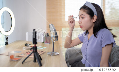 Beautiful women with social media influences are teaching makeup and use cosmetics, In front of the camera to recording vlog video live streaming, Online business on concept of beauty bloggers. Beautiful women with social media influences are teaching makeup and use cosmetics, In front of the camera to recording vlog video live streaming, Online business on concept of beauty bloggers. 101986592