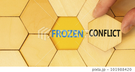 Frozen conflict symbol. Concept words Frozen conflict typed on wooden puzzles. Beautiful yellow table yellow background. Businessman hand. Business and Frozen conflict concept. Copy space. Frozen conflict symbol. Concept words Frozen conflict typed on wooden puzzles. Beautiful yellow table yellow background. Businessman hand. Business and Frozen conflict concept. Copy space. 101988420
