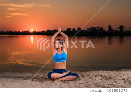 yoga at sunset on the beach. 101991276