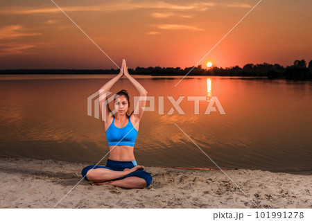 yoga at sunset on the beach. 101991278