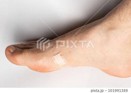 Injured foot with band aid Injured foot with band aid 101991389