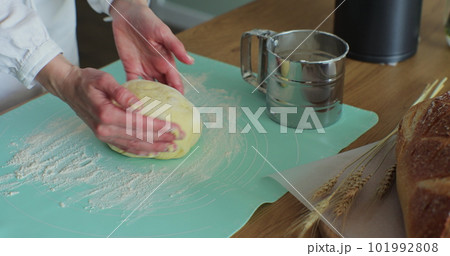 Woman kneading the dough in the kitchen. Cooking at home, enjoying hobby. Making hand-made bread. Woman kneading the dough in the kitchen. Cooking at home, enjoying hobby. Making hand-made bread. 101992808