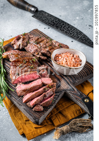 Roasted Mutton leg steaks, sliced lamb meat. Gray background. Top view Roasted Mutton leg steaks, sliced lamb meat. Gray background. Top view 101997855
