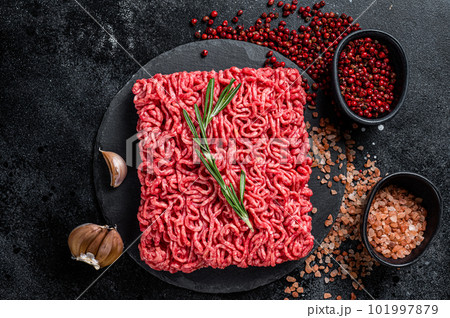 Uncooked beef veal Mince Meat, raw ground meat. Black background. Top view Uncooked beef veal Mince Meat, raw ground meat. Black background. Top view 101997879