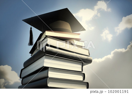 The traditional cap of Graduate lies on stack of thick textbooks, books, against the blue sky, concept of graduation from school, university 102001191
