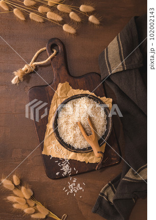 Long grain rice on rustic countertop 102002143