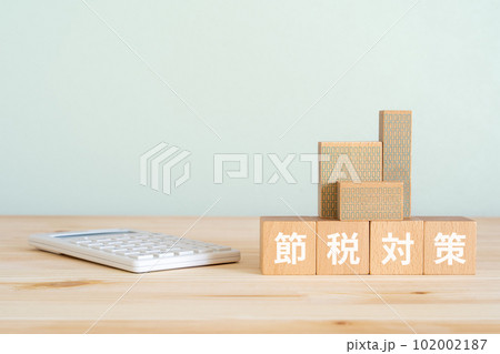 節税対策と書かれたブロックと電卓と建物のオブジェ 102002187