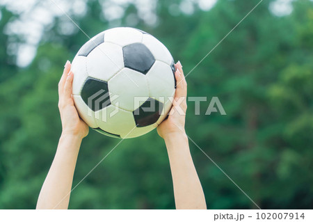 サッカーボールを持つ・かがげる女性の手元 102007914