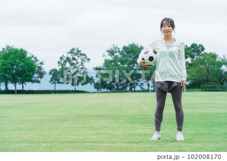 運動場でサッカーボールを持つサッカーファン・サポーターの日本人女性 運動場でサッカーボールを持つサッカーファン・サポーターの日本人女性 102008170