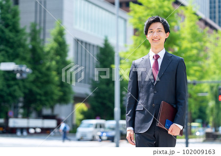 新入社員の男性ビジネスマンがてオフィス街で仕事をする 新入社員の男性ビジネスマンがてオフィス街で仕事をする 102009163