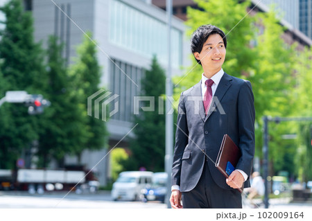 新入社員の男性ビジネスマンがてオフィス街で仕事をする 新入社員の男性ビジネスマンがてオフィス街で仕事をする 102009164