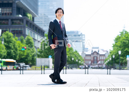 新入社員の男性ビジネスマンがてオフィス街で仕事をする 102009175