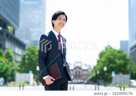 新入社員の男性ビジネスマンがてオフィス街で仕事をする 102009176