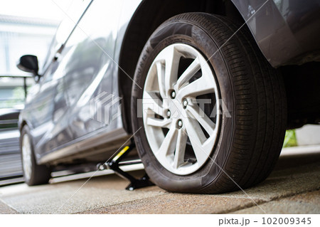 Close up photograph of damaged wheel - flat tire of an accident vehicle. A car have an accident on a wheel. 102009345