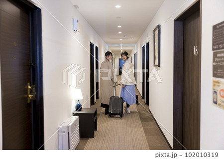 チェックインをしてホテルの廊下を歩く若い女性たち チェックインをしてホテルの廊下を歩く若い女性たち 102010319